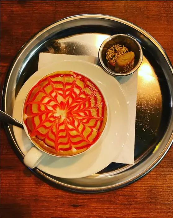 Kırmızı desenli latte art ile servis edilen kahve